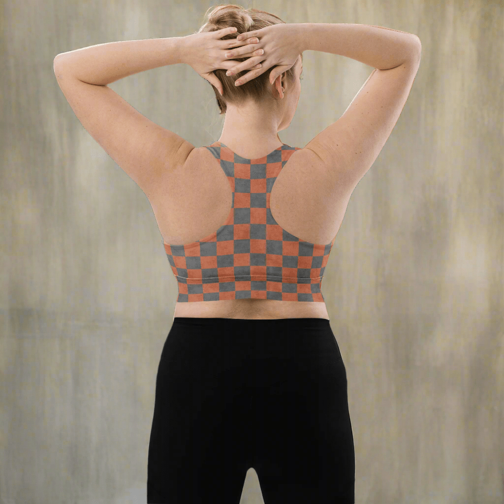 Person wearing a checkered sports bra and black leggings on a neutral background