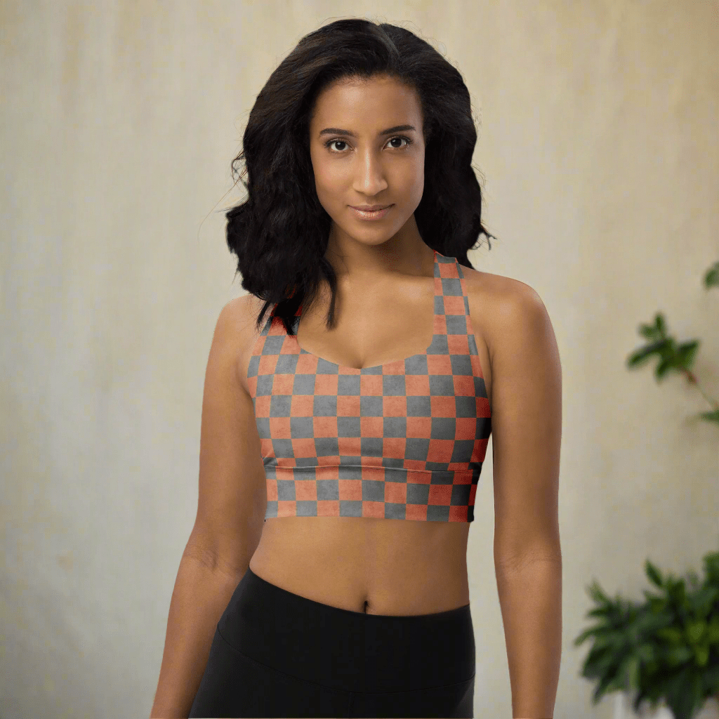 Woman wearing a checkered sports bra and black leggings on a neutral background