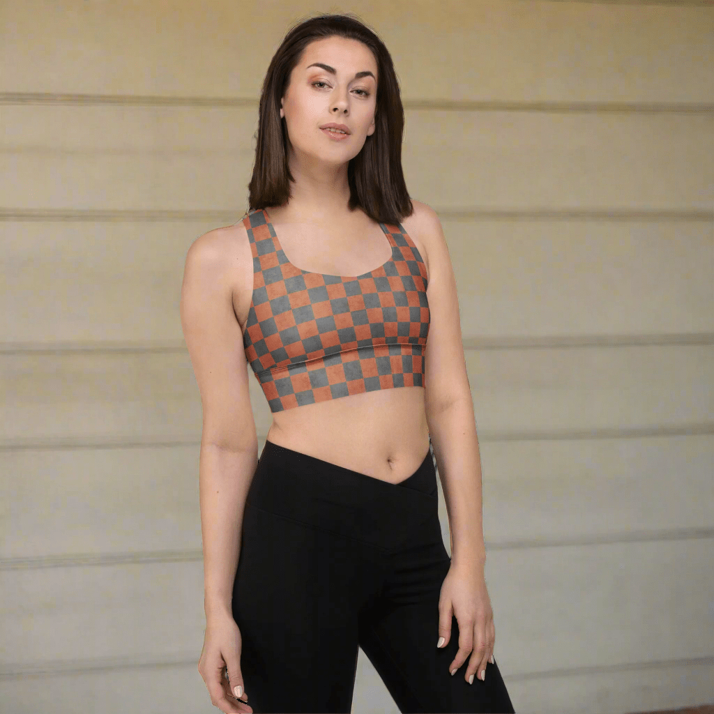 Woman wearing a patterned sports bra and black leggings against a neutral background