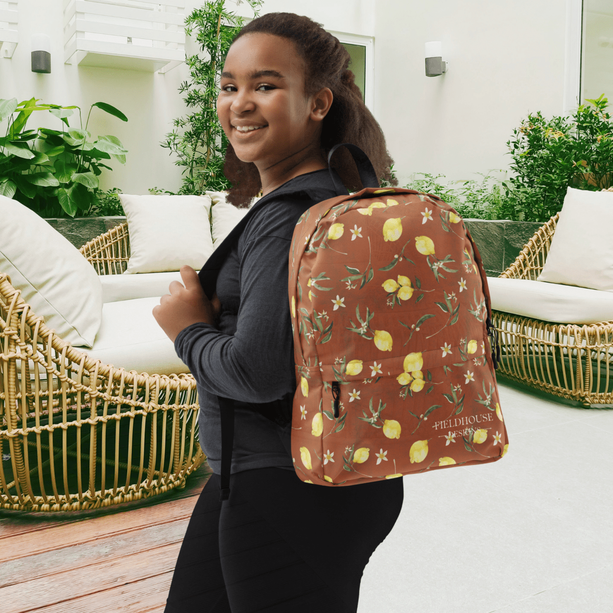 Person wearing a lemon-patterned backpack in an outdoor setting
