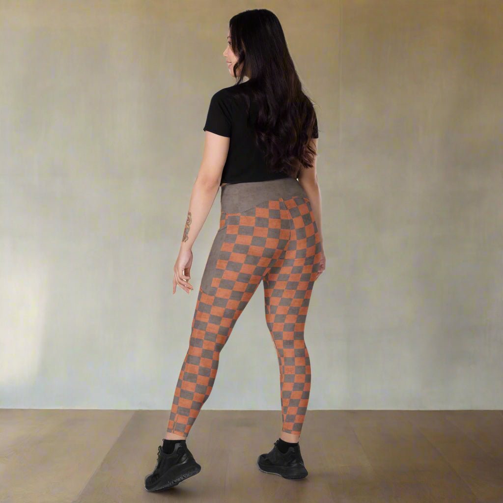 Woman wearing checkered leggings on a neutral background
