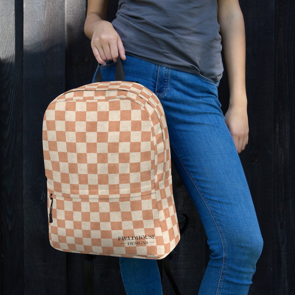 Person wearing an orange and white checkered backpack with 'Fieldhouse Designs' branding.