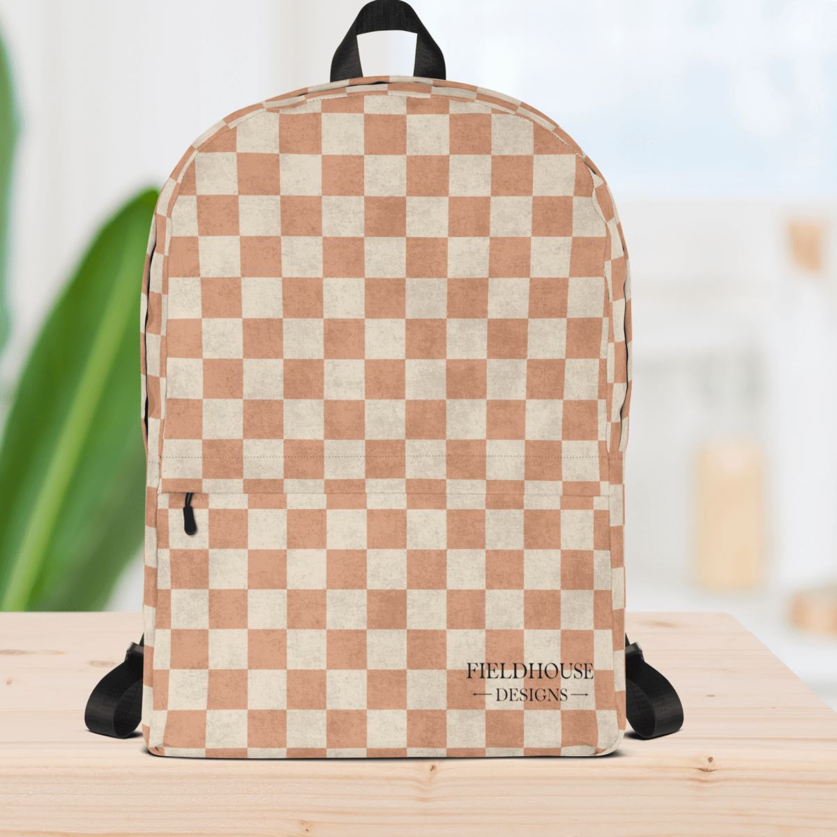 Checkered backpack with 'Fieldhouse Designs' logo on a wooden surface