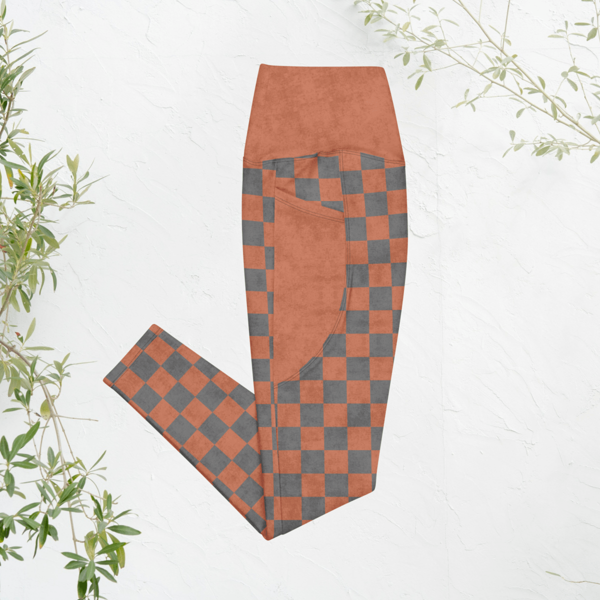 Checkered leggings with terracotta and gray pattern on a white background