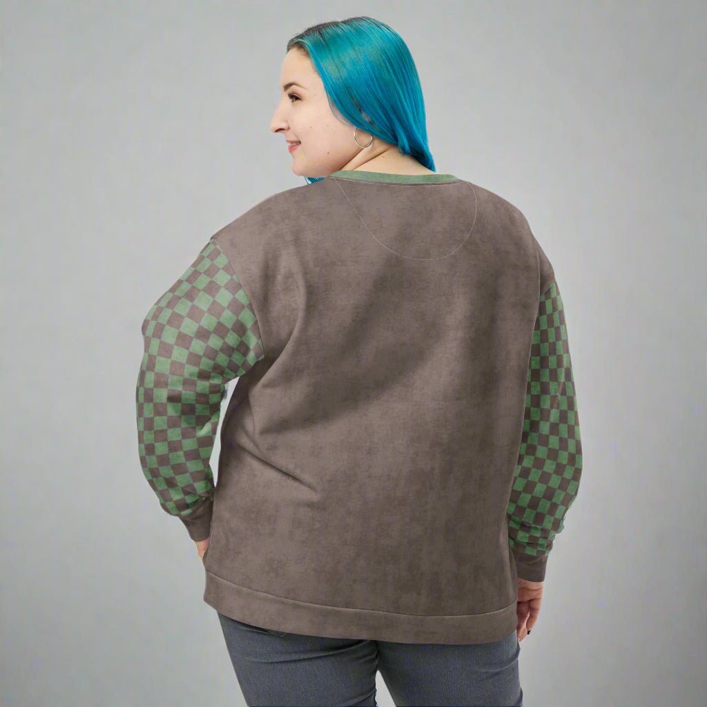 Person wearing a brown sweatshirt with green checkered sleeves on a white background