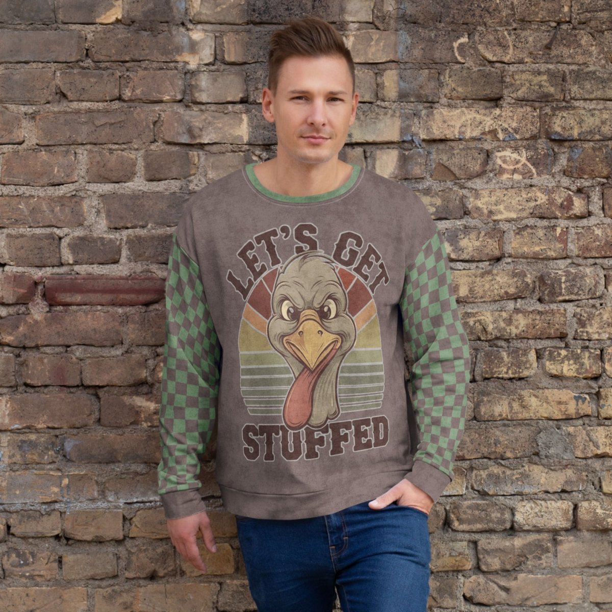 Man wearing a sweater with a turkey graphic and text against a stone wall.