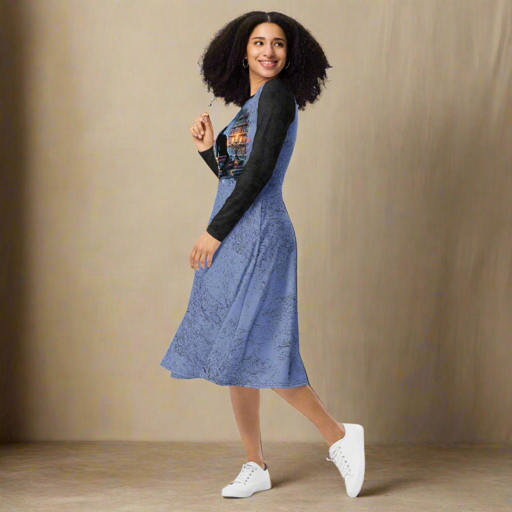 Woman wearing a blue dress with black sleeves on a neutral background