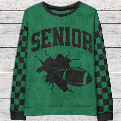 Green sweatshirt with 'Senior' and football graphic on a wooden surface