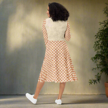 Woman wearing a checkered dress with a beige top on a white background