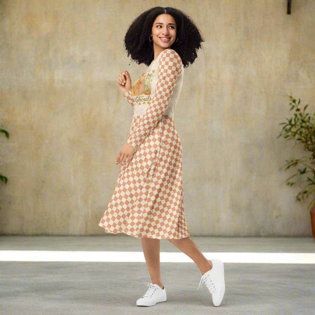 Woman wearing a patterned dress with white sneakers in a neutral setting