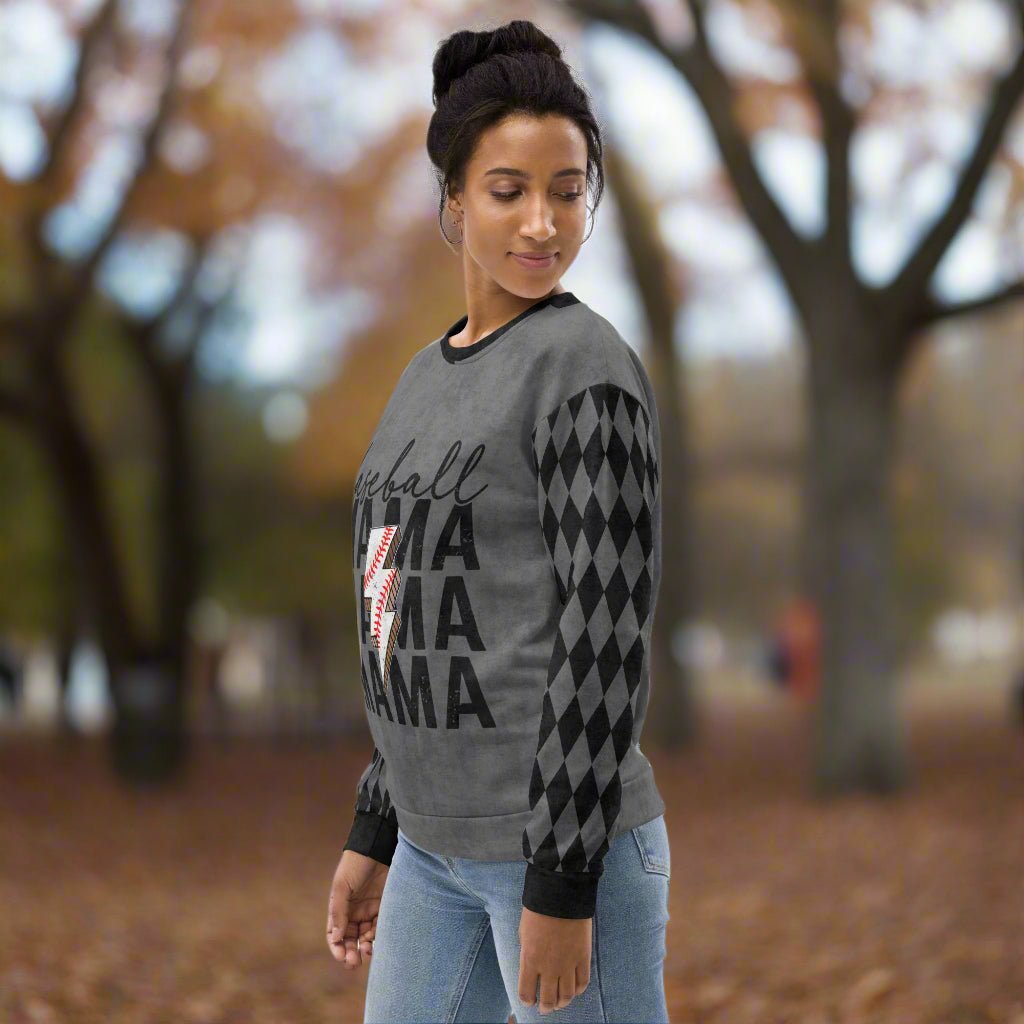 Woman wearing a gray sweater with black argyle pattern and 'Baseball Mama' text outdoors