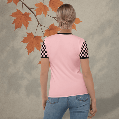 Person wearing a pink shirt with checkered sleeves against a neutral background with autumn leaves.