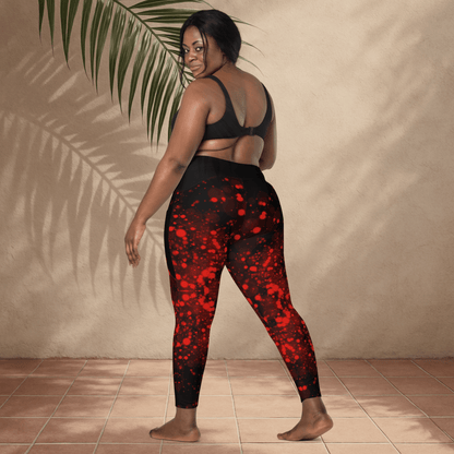 Woman wearing black and red patterned leggings standing against a beige wall.