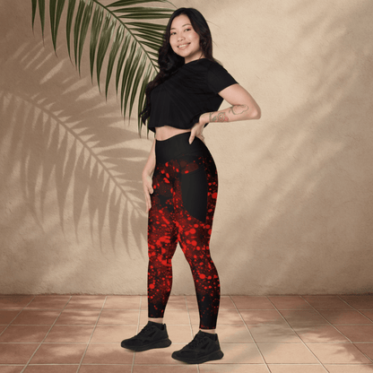 Woman wearing black and red patterned leggings with a black crop top against a beige wall.