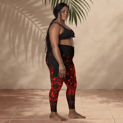 Woman wearing black and red patterned leggings standing against a beige wall.