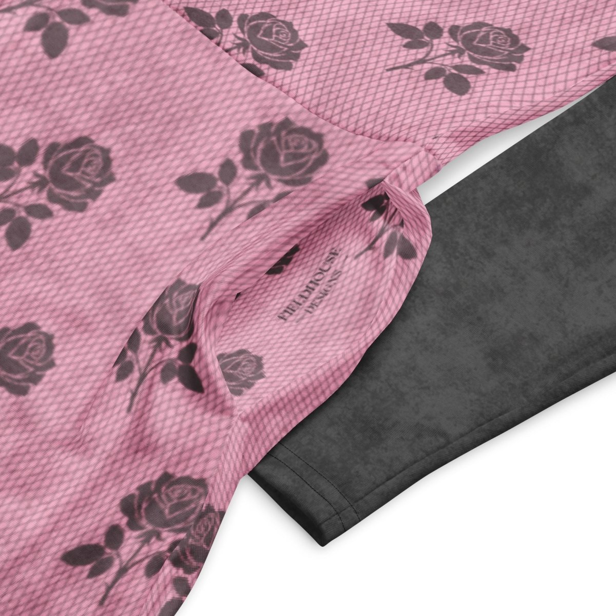 Pink fabric with charcoal rose pattern and black textured fabric underneath on a white background