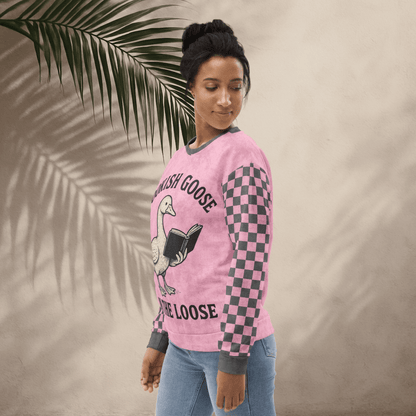 Person wearing a pink long-sleeve shirt with a graphic design on a beige background