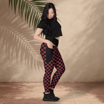 Woman wearing black and burgundy checkered pants with a plain background
