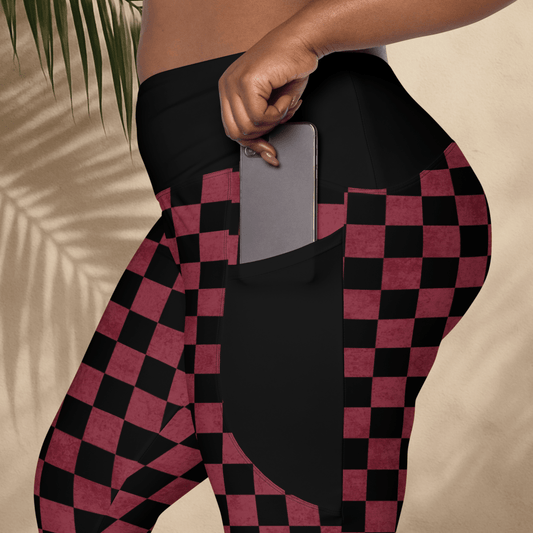Person wearing black and burgundy checkered leggings with a pocket holding a phone.