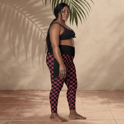 Woman wearing black and burgundy checkered leggings against a beige wall.