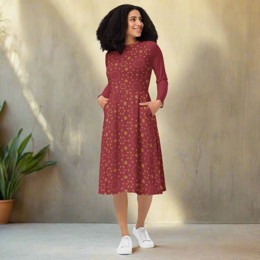 Woman wearing a burgundy boho patterned dress on a neutral background