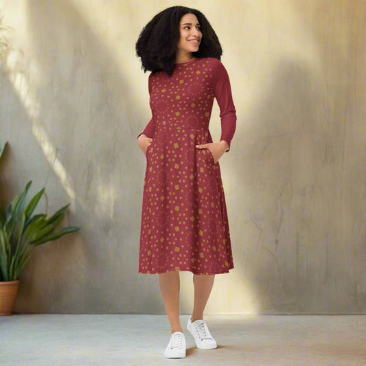 Woman wearing a burgundy boho patterned dress on a neutral background