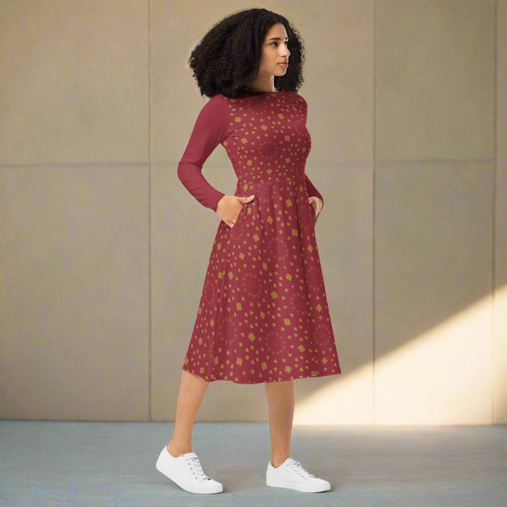 Woman wearing a burgundy boho patterned dress with white sneakers against a neutral background