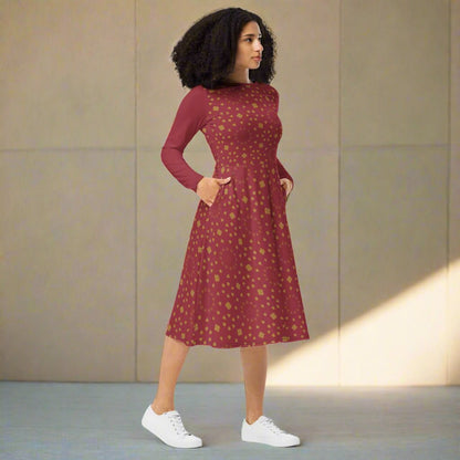 Woman wearing a burgundy boho patterned dress with white sneakers against a neutral background
