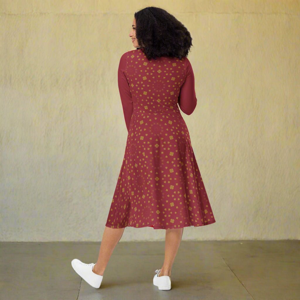 Woman wearing a burgundy boho patterned dress on a neutral background