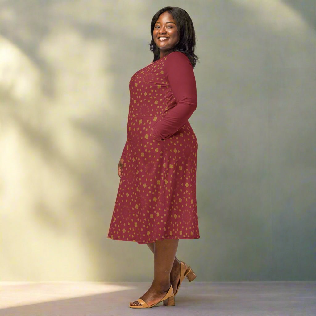 Woman wearing a burgundy boho dress with gold patterns against a neutral background