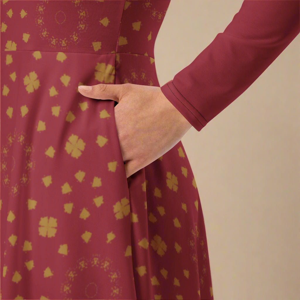 Burgundy dress with gold floral pattern worn by a person, against a beige background