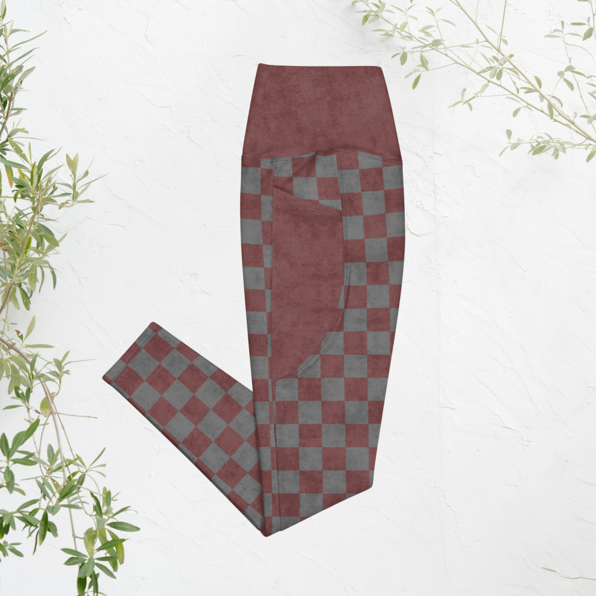 burgundy and gray checkered pants on a white background with green leaves.