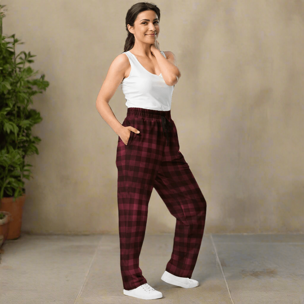 Woman wearing red plaid pants and a white top on a neutral background