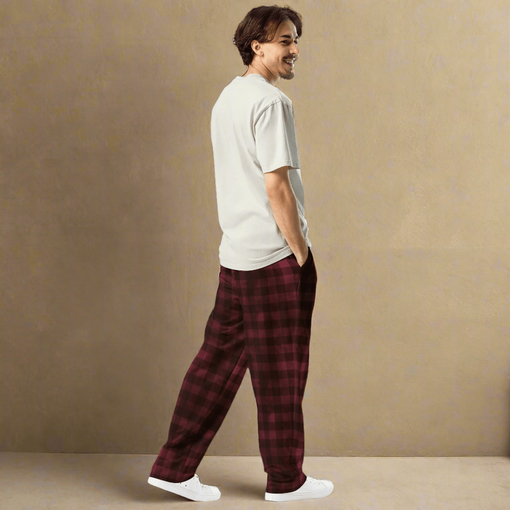 Man wearing a white t-shirt and red plaid pants against a beige background