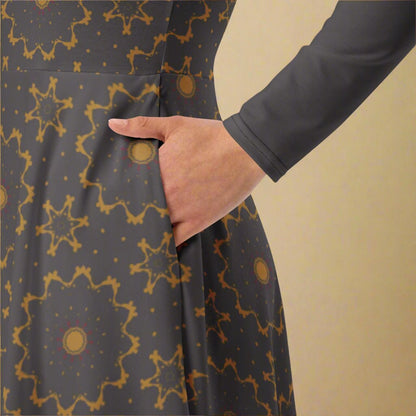 Person wearing a gray dress with gold geometric patterns against a beige background