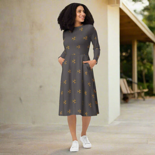Woman wearing a gray dress with star patterns standing outdoors.