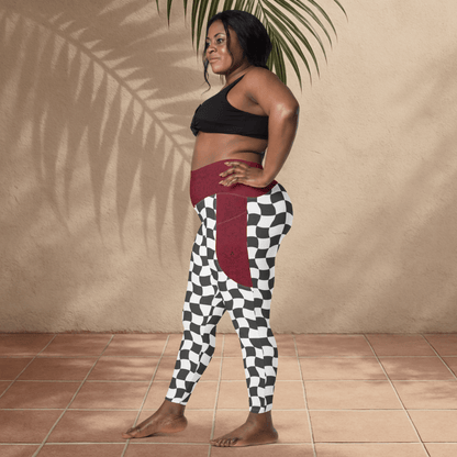 Woman wearing a black sports bra and checkered leggings against a beige wall.