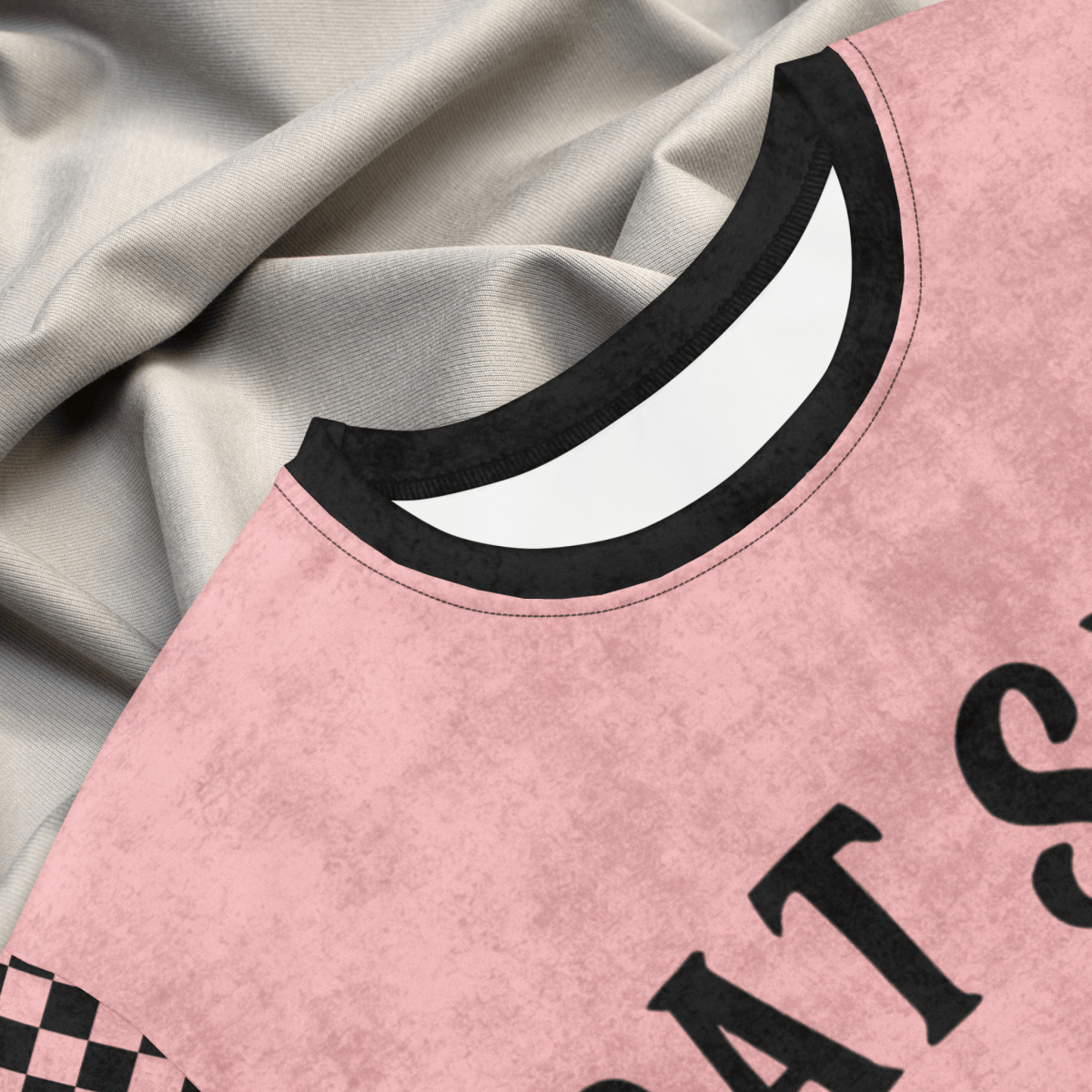 Pink shirtdress with black trim and text on a textured fabric background