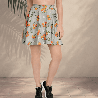 Person wearing a floral skirt with an orange and green pattern against a beige wall.
