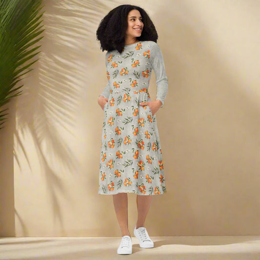 Woman wearing a n orange and floral print dress on a neutral background 