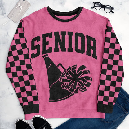Pink sweatshirt with 'Senior' and cheerleader graphic on a marble surface.