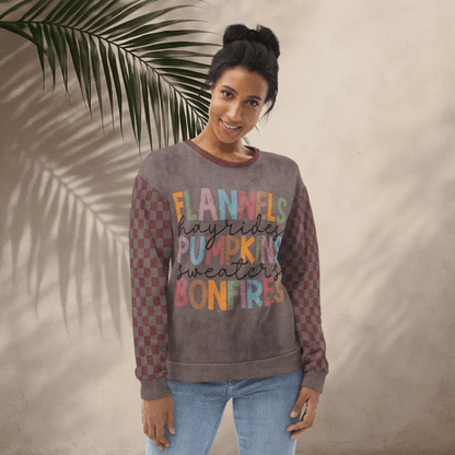 Woman wearing an espresso and burgundy sweatshirt with colorful text against a beige wall with a leafy branch.
