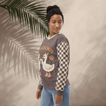 Woman wearing a sweater with a goosebumps design, standing against a neutral background with a leaf.