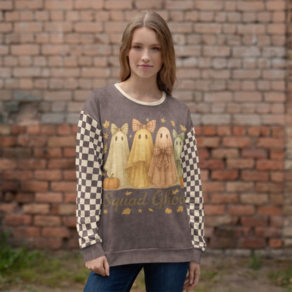 Woman wearing a sweater with ghost design and 'Squad Ghouls' text against a brick wall.
