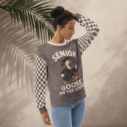 Woman wearing a sweater with 'Senior Goose on the Loose' design against a beige background