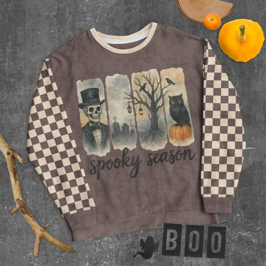 Sweatshirt with Halloween-themed design featuring an owl, pumpkin, and text on a checkered background.