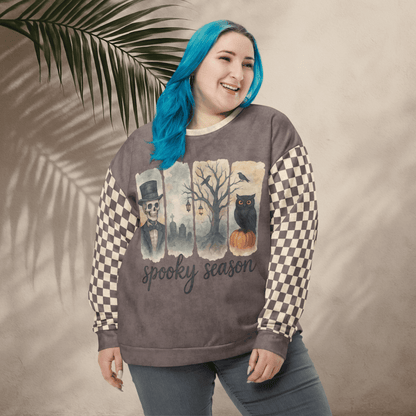 Person wearing a 'spooky season' sweatshirt with checkered sleeves against a beige background
