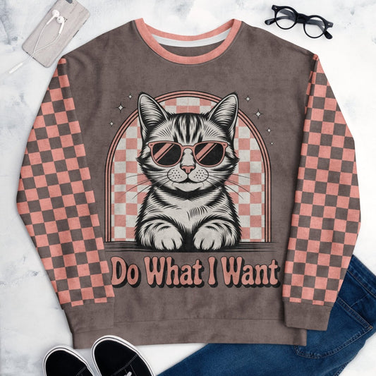 Espresso sweatshirt with a sunglasses-wearing tabby cat and “I Do What I Want” text; sleeves feature pink-and-espresso checkerboard pattern with pink collar and cuffs.