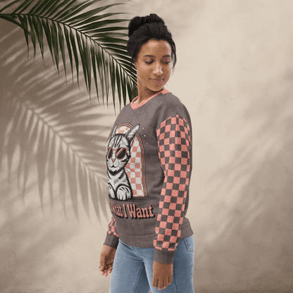 model wearing Espresso sweatshirt with a sunglasses-wearing tabby cat and “I Do What I Want” text; sleeves feature pink-and-espresso checkerboard pattern with pink collar and cuffs.