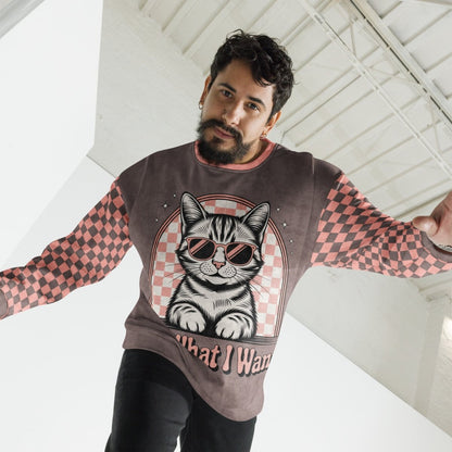 man wearing Espresso sweatshirt with a sunglasses-wearing tabby cat and “I Do What I Want” text; sleeves feature pink-and-espresso checkerboard pattern with pink collar and cuffs.